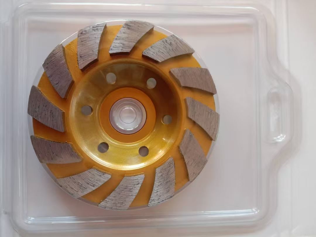 A single-row turbo diamond cup wheel, gold-painted with one ring of swept segments, in its blister pack